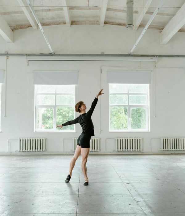 Woman in a light active pose in a minimalist studio.
